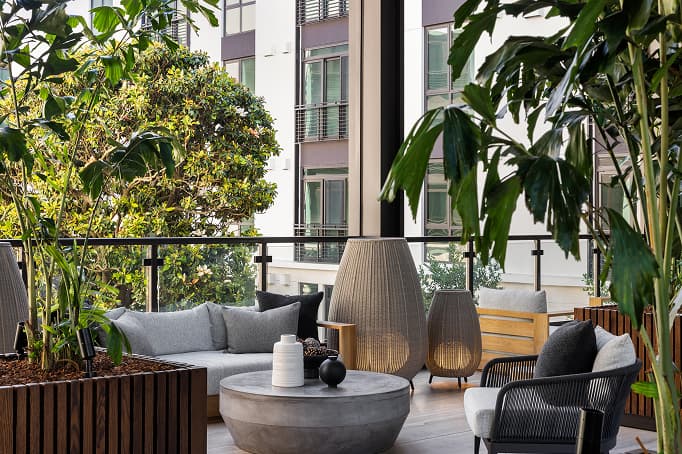 Private balcony lounge at a Treasure Island residence featuring modern outdoor seating and lush greenery in a contemporary waterfront community.