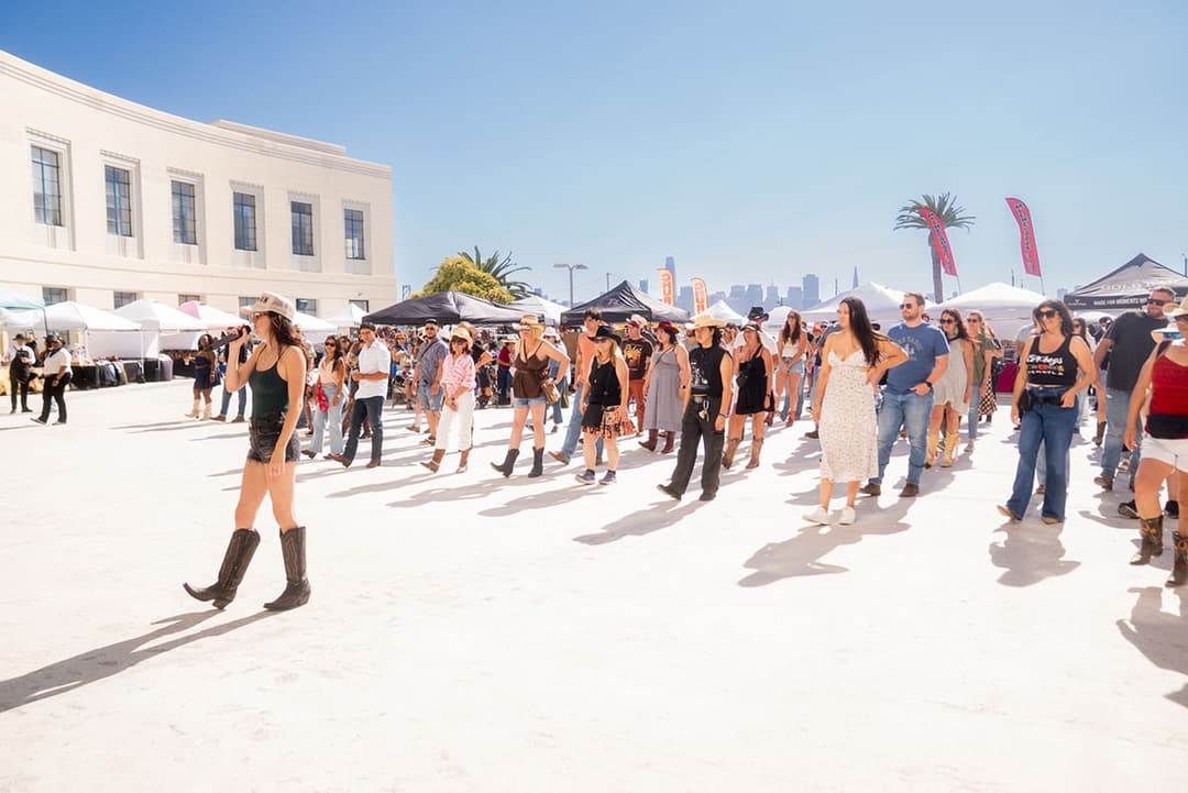 Attendees line dance at the Country on the Bay festival on Treasure Island.