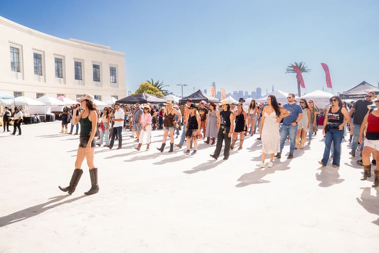 Attendees line dance at the Country on the Bay festival on Treasure Island.