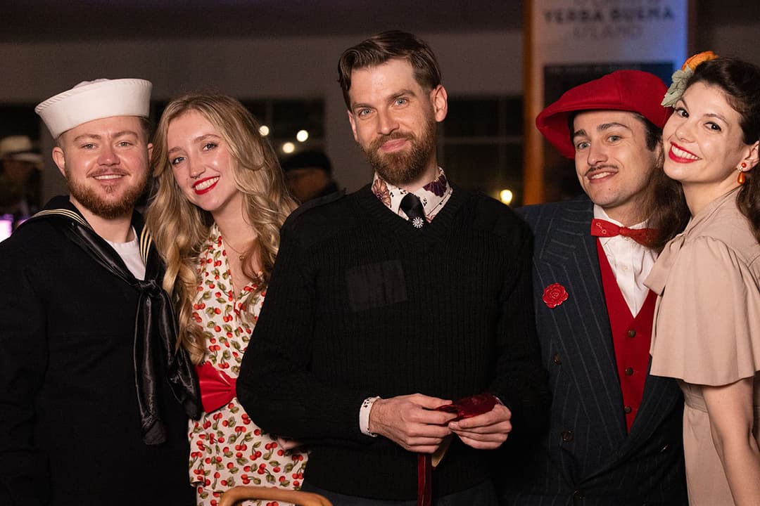 Guests in vintage attire gather at a swing dance event on Treasure Island.