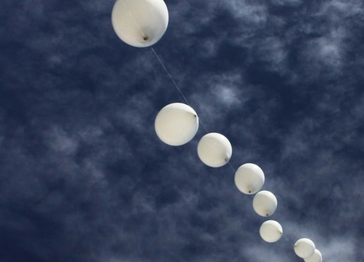 white balloons in the blue skies of treasure island