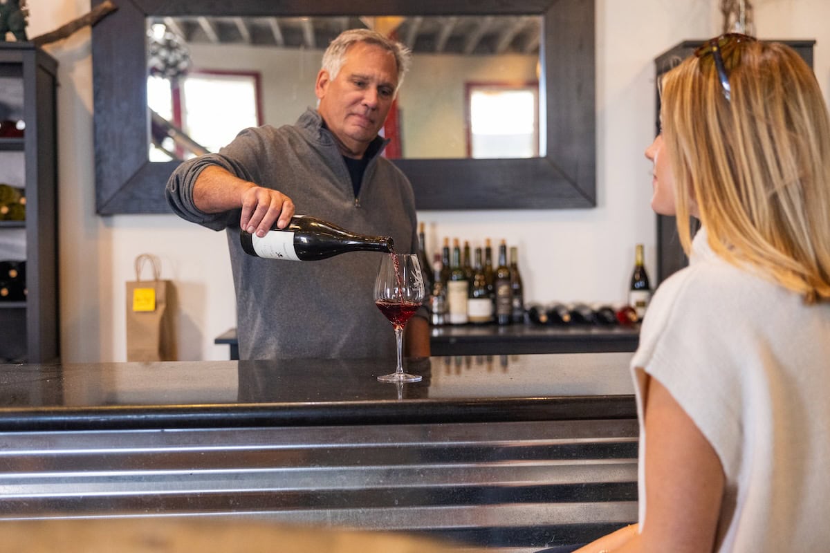 Bartender pouring a glass of wine for a woman