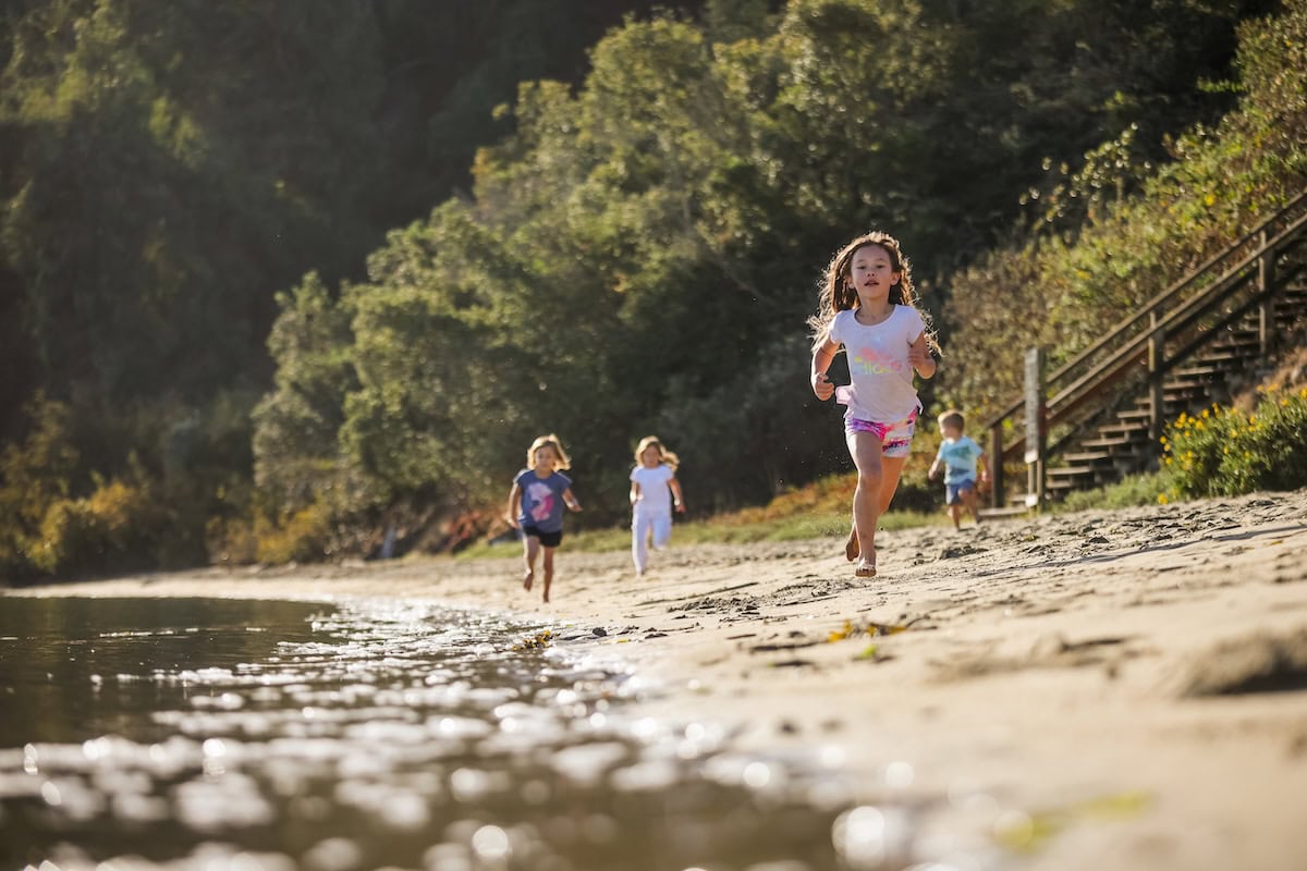 Children running on a beach in Treasure Island